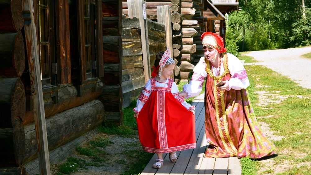 Мама с дочкой в старинном сибирском селе в народных костюмах.
