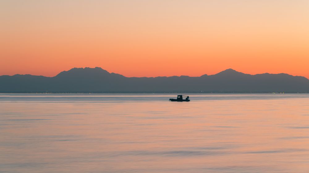 Одинокая лодка в силуэте рассвета