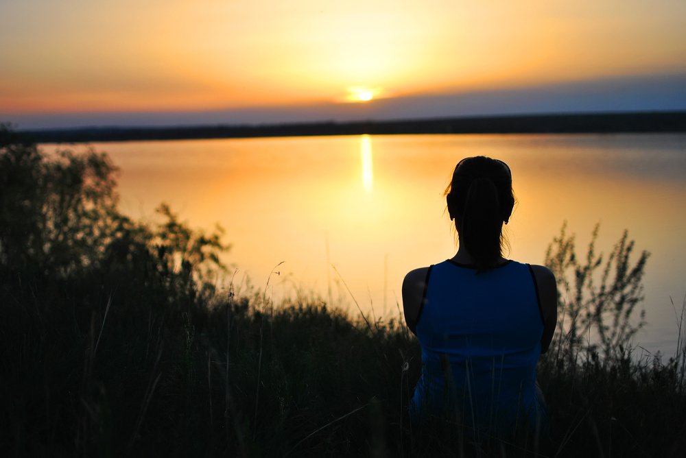 Мечтательная девушка провожает закат.