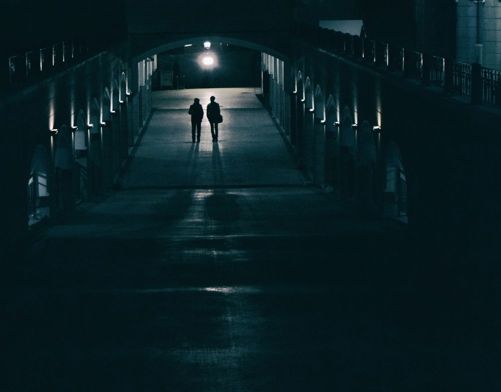 Two silhouette in a dark street