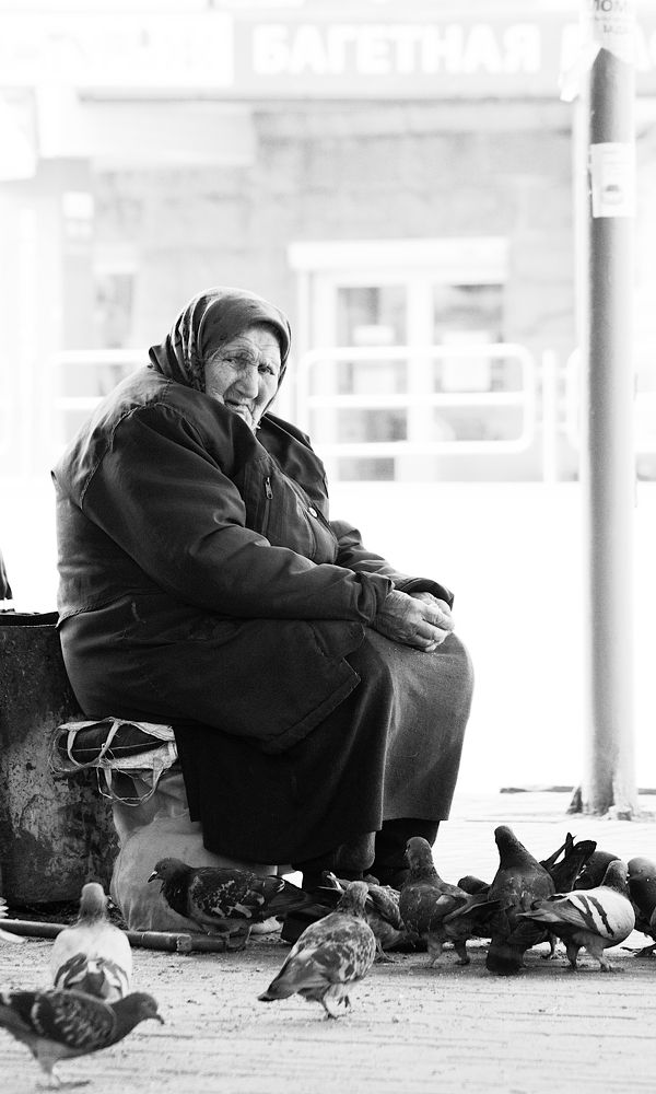 Портрет бабушки, которая кормит голубей на улице