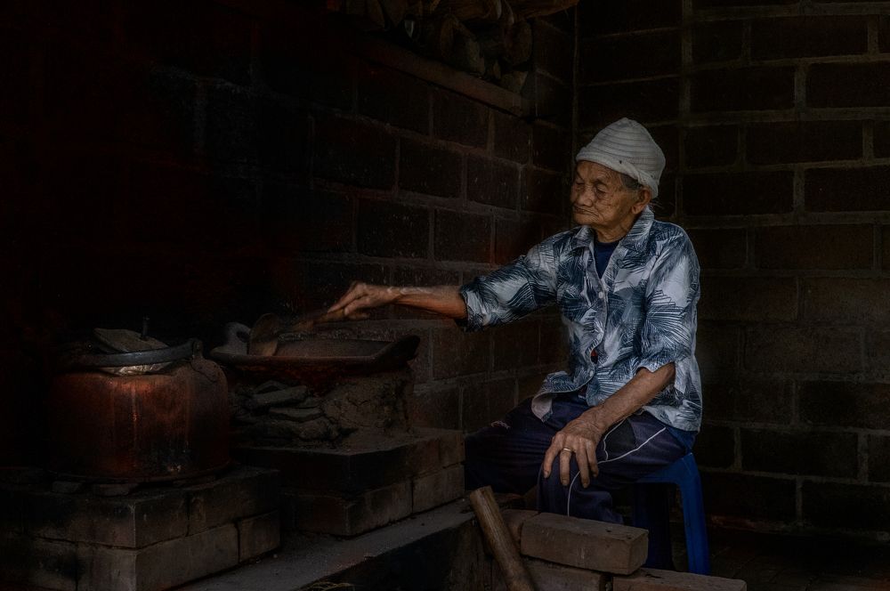 Old Indonesian Woman roasting Kopi Luak coffee beans