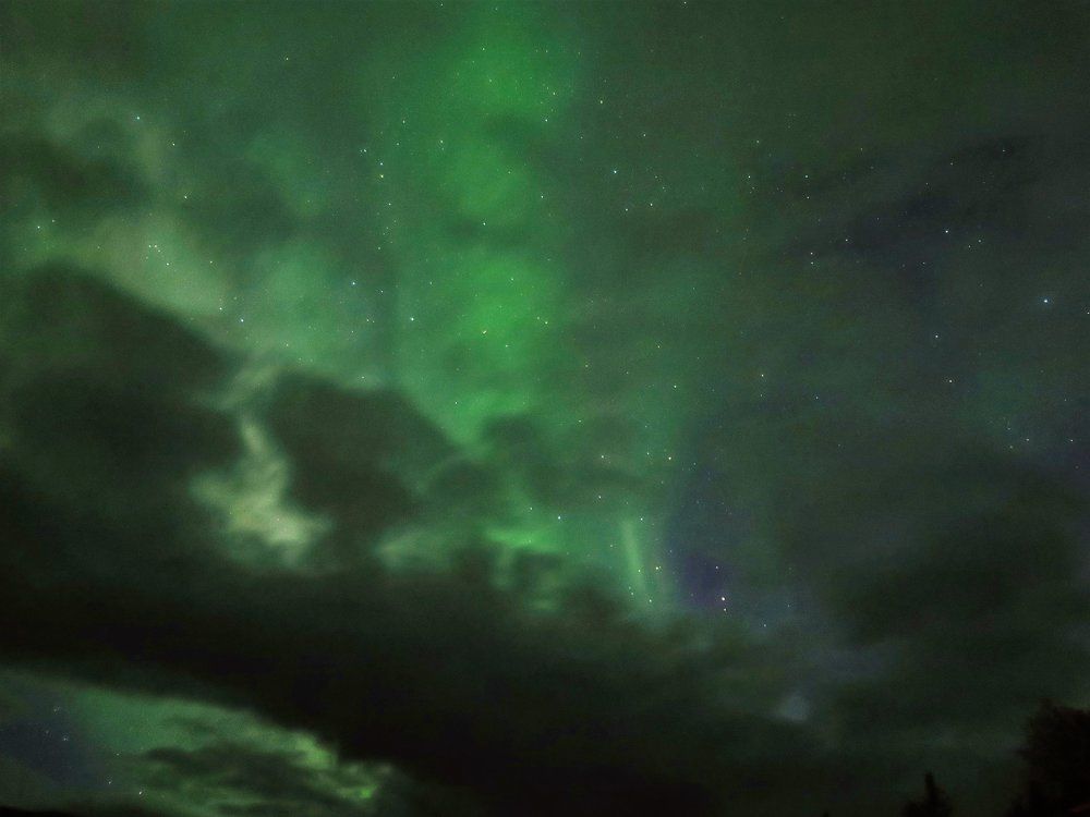Северное сияние сквозь облака Aktse, Швеция