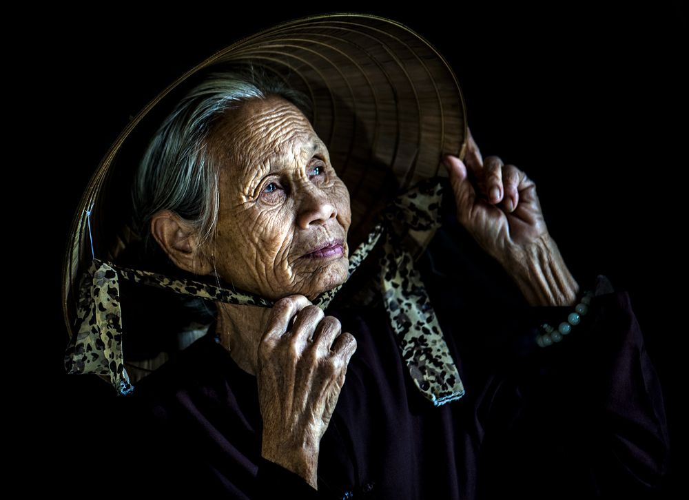 The old lady patched the fishnets at the village