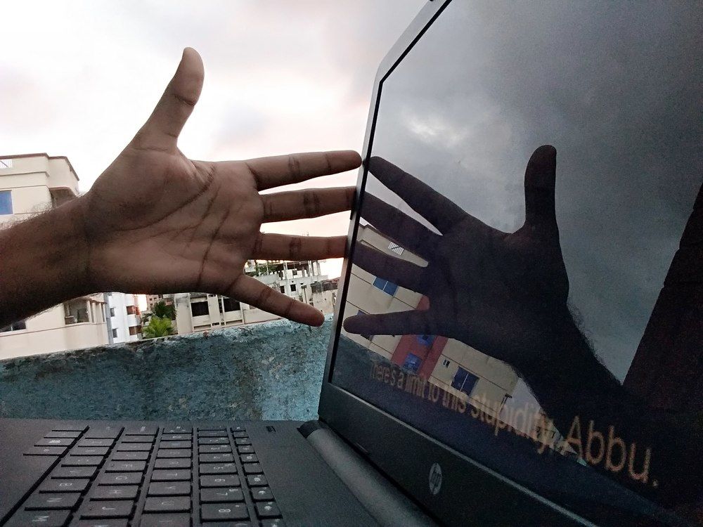 mirror image of hand on laptop screen