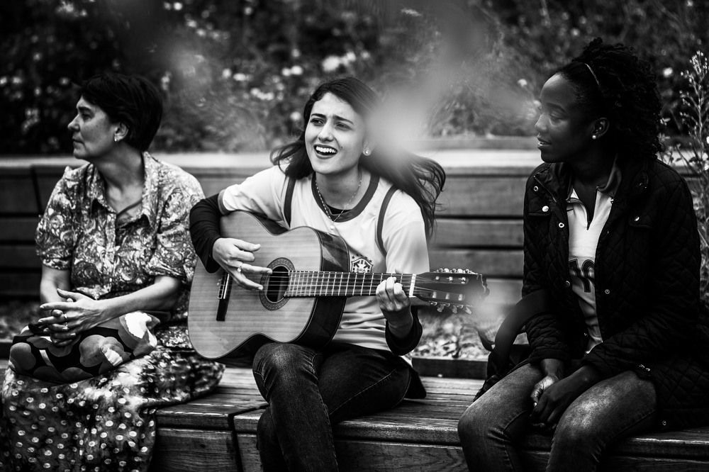 Бразильская девушка поет под гитару в парке