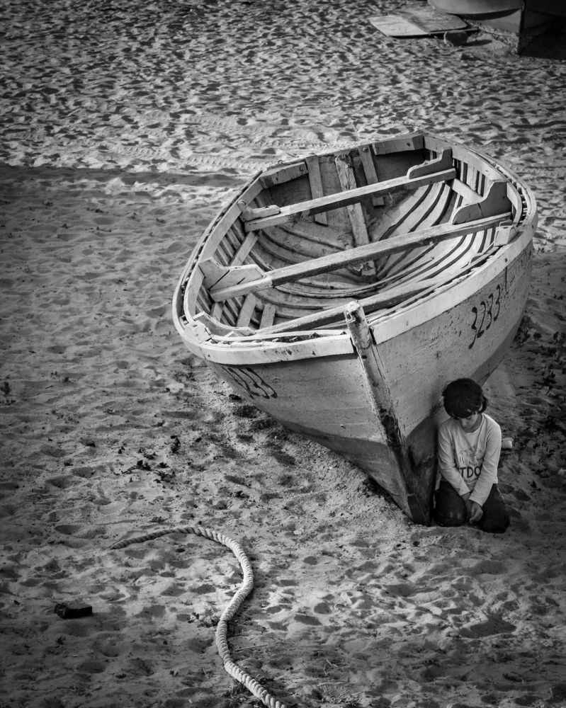 HIidden in the shadow of the boat
