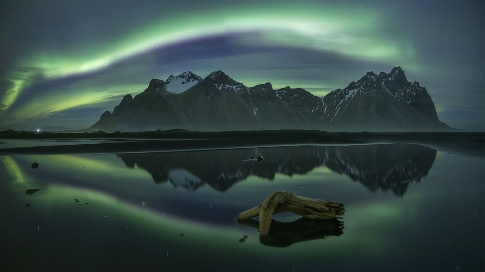 Northern lights, reflection and Vestrahorn. Iceland.