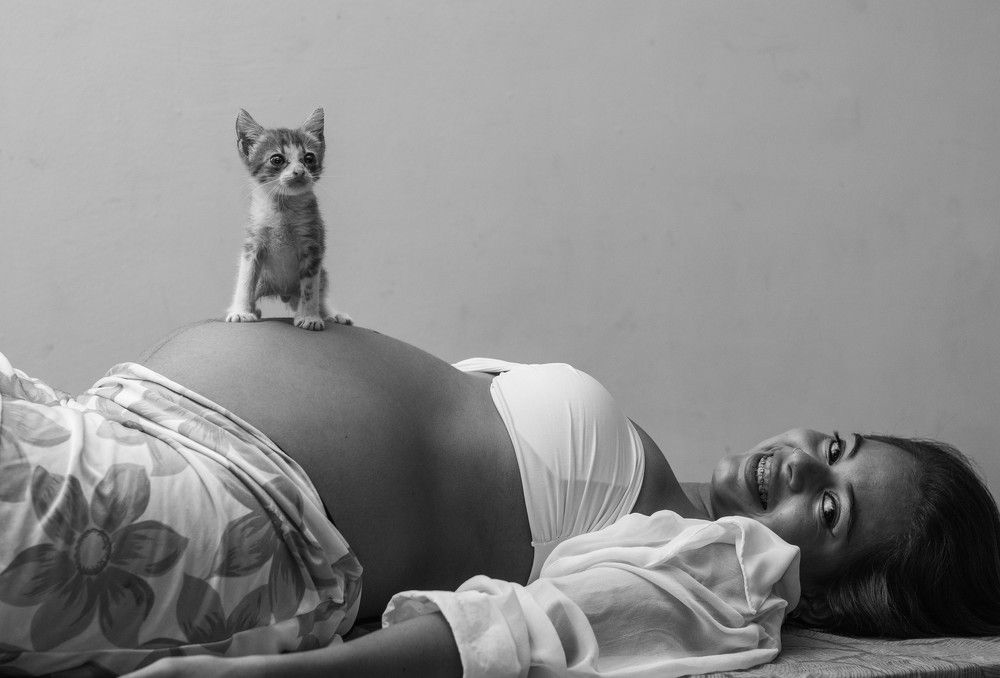 New mother with her baby and young cat