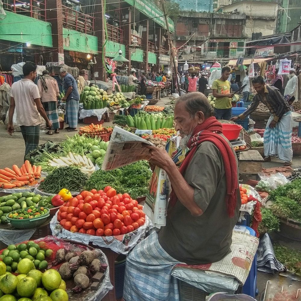 a vegetables shopkeeper reading a newspaper