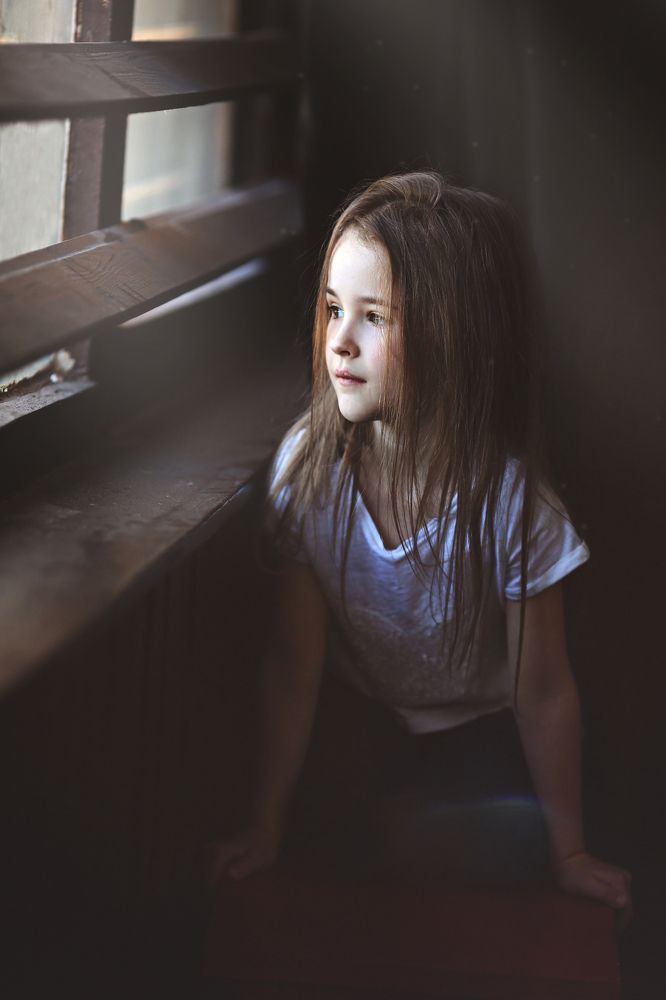 девочка смотрит в окно