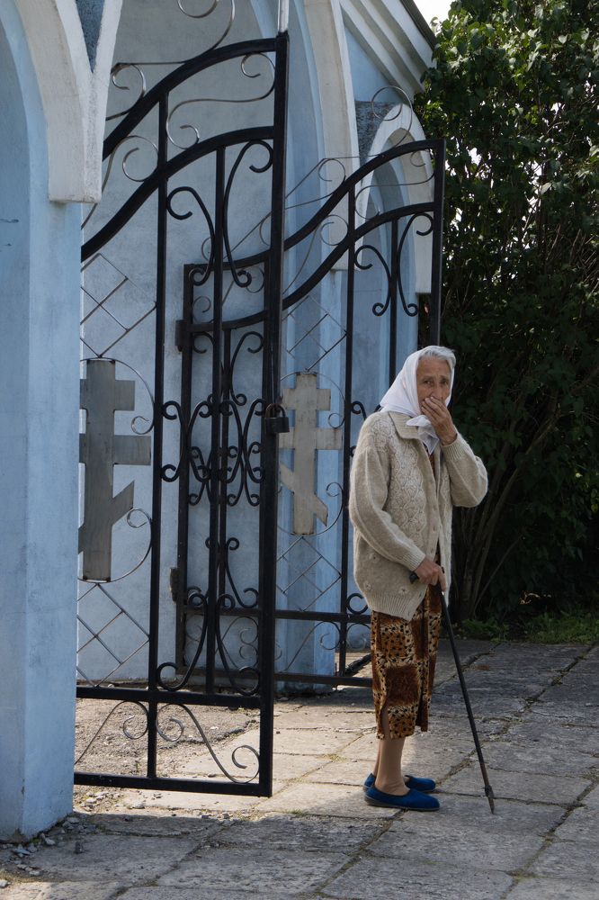 Бабушка у ворот церкви
