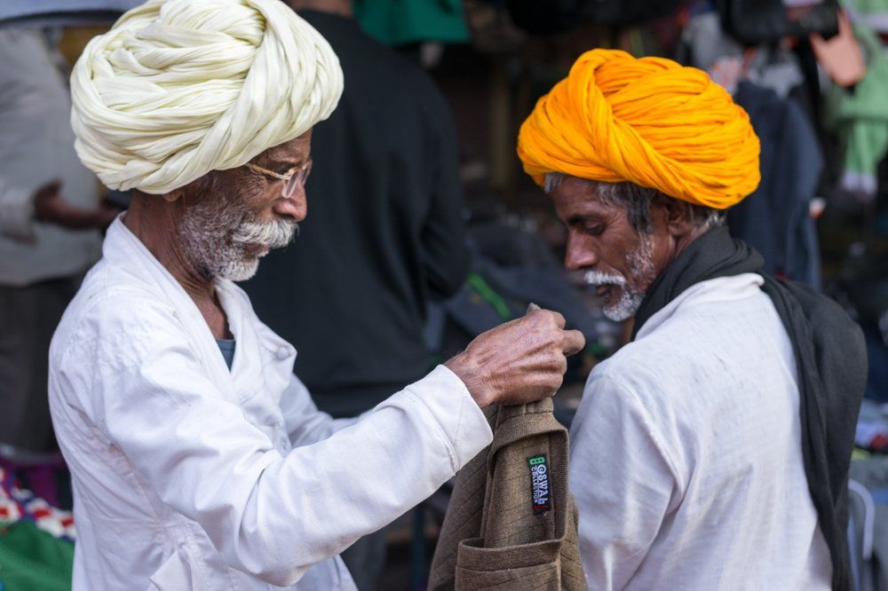 the father measuring if the sweater fits to son