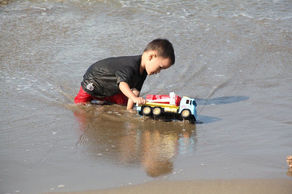 playing toy cars on the beach