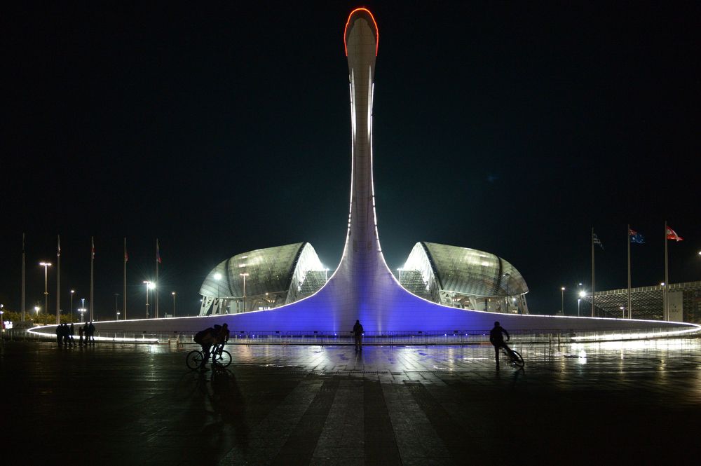 Олимпийский факел на фоне стадиона Фишт в Сочи