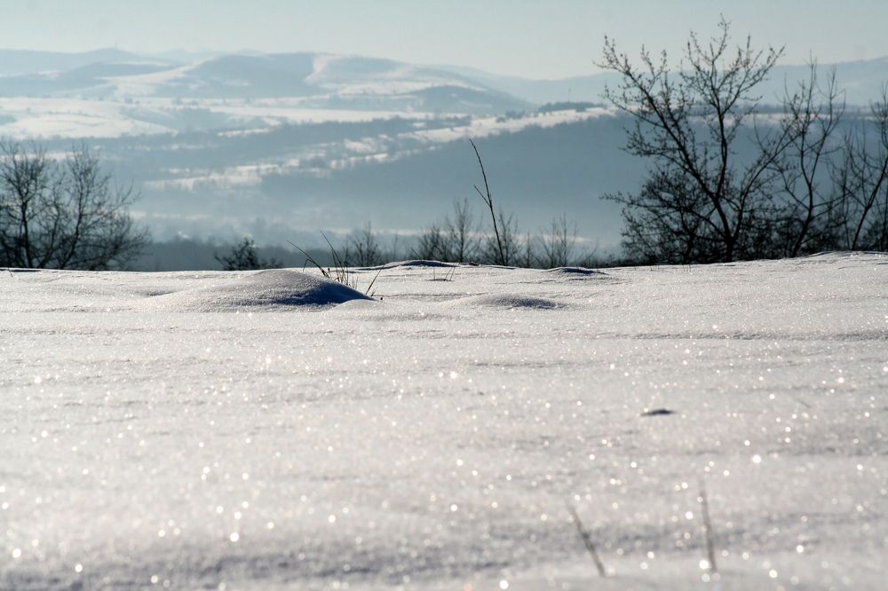 Snow mound against the background of the mountains.