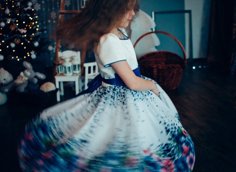 The girl whirls near the Christmas tree