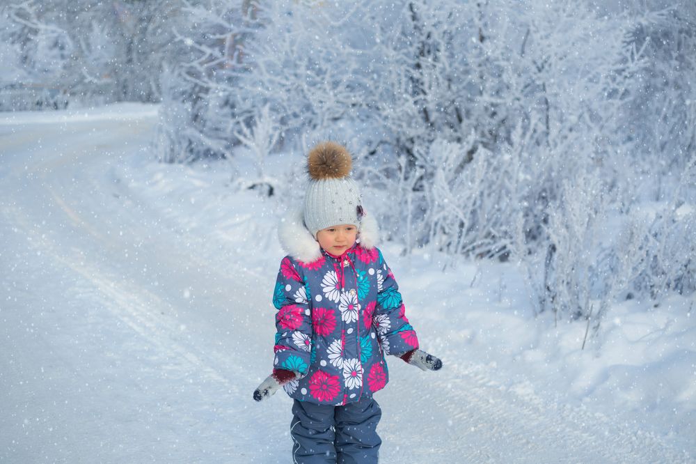 Ребенок под снегопадом.