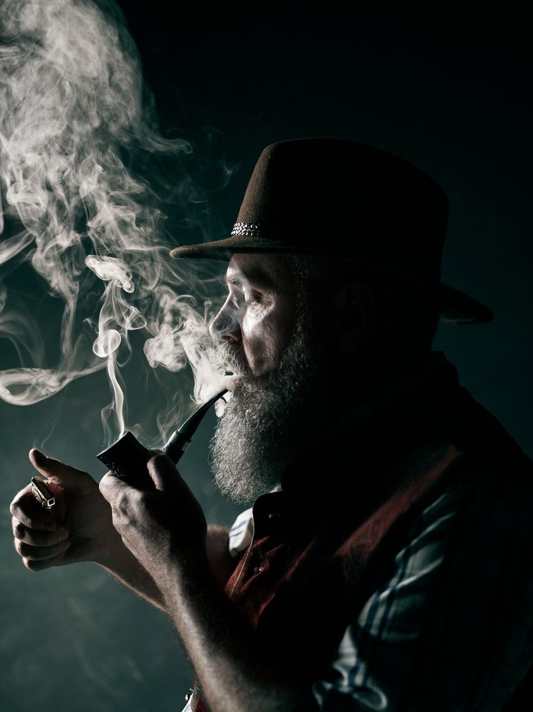 Мужчина курит трубку