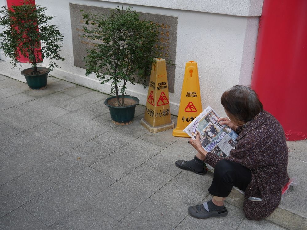 A senior citizen reading her newspapers
