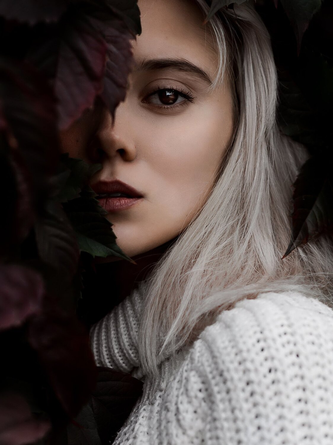 Mysterious girl in the leaves of wild grapes