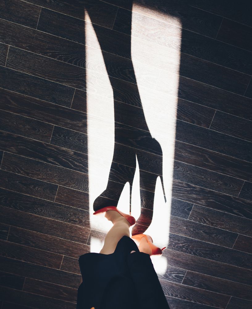 Shadow of beautiful women's feet in high heels