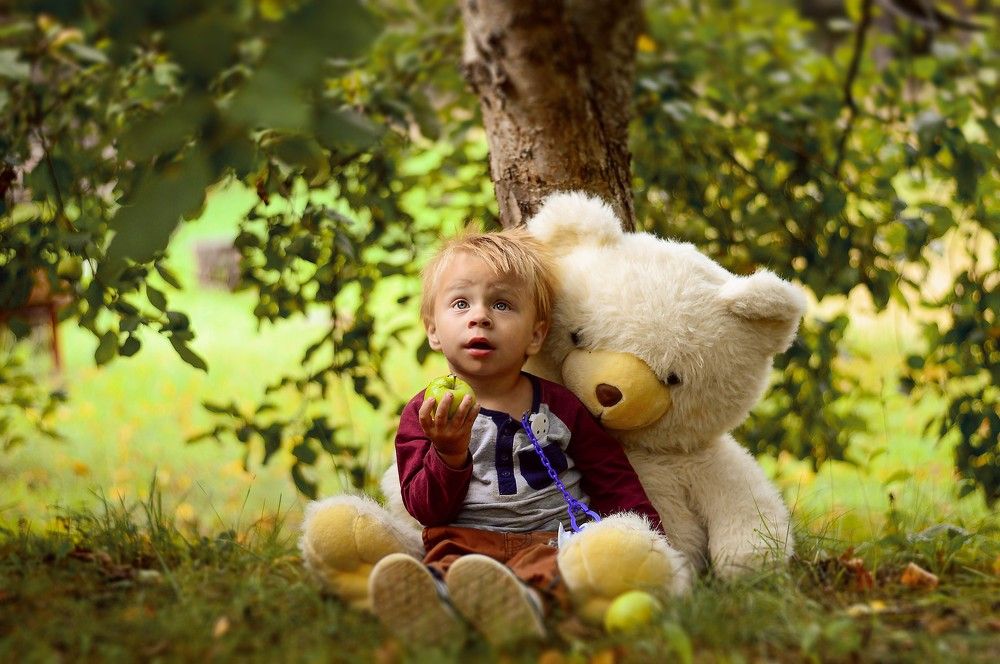 Toddler siting under the tree.