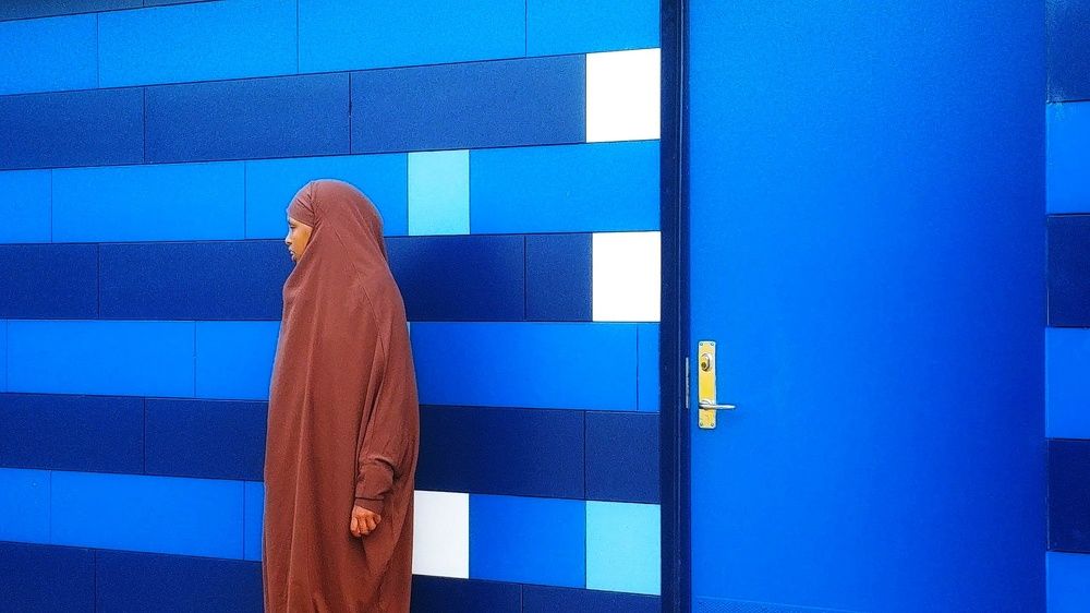 Woman with brown chador and blue wall