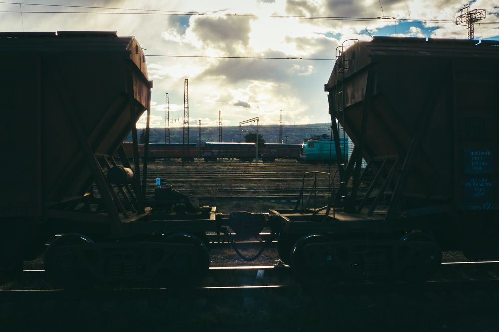 Trains standing face to face at sunset.