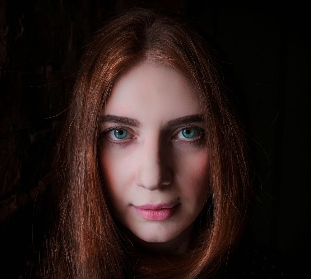 Из темноты.