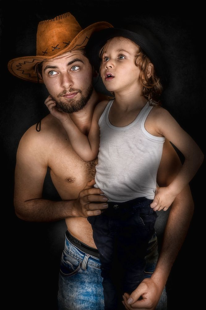 The cowboy and his young son look at something