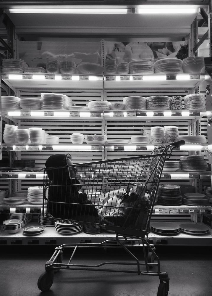 Boy sleeps in the shop cart