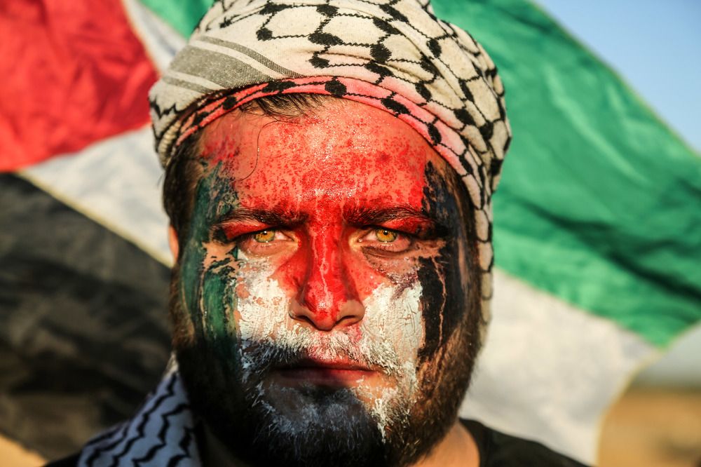 A Palestinian young man covers her face during a protest calling for lifting the Israeli blockade on Gaza