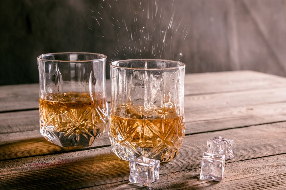 Two glasses of whiskey with ice cubes