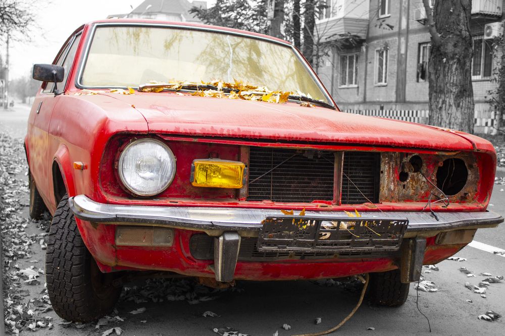 Old red car on a city street.