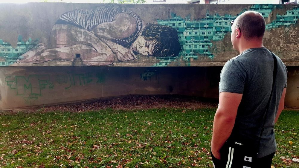 Young man looking at a drawing on the wall