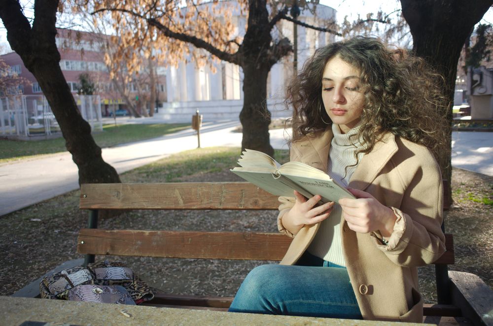 Girl reading a book in a  park