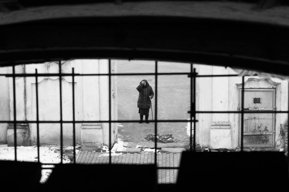 Woman in front of a closed temple in the village of Yurovichi in Belarus
