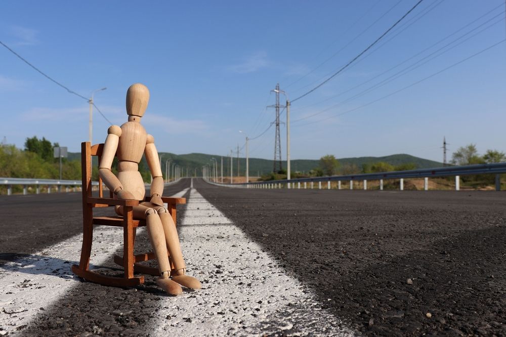 Деревянный человечек в кресле