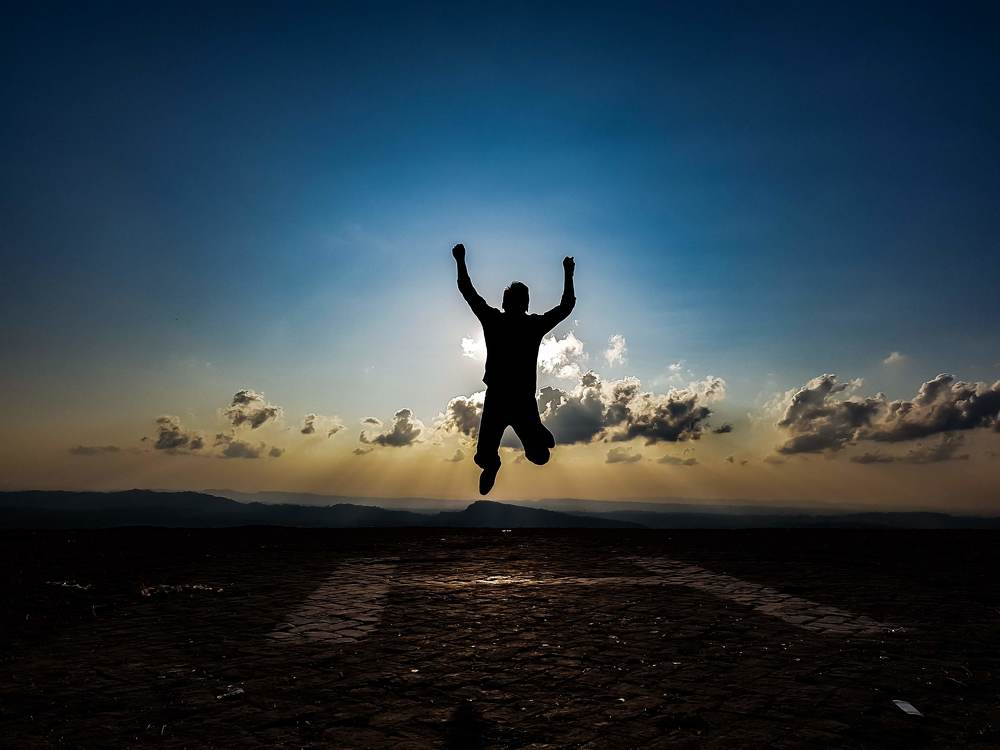 Man silhouette jump happy