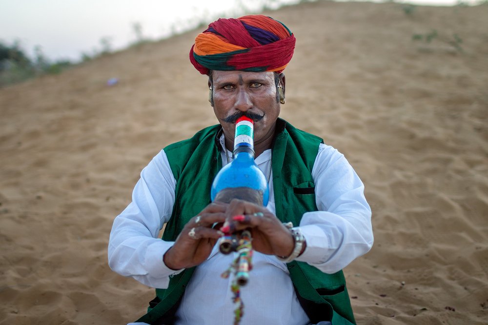 A snake charmer playing his murli in the desert of Pushkar