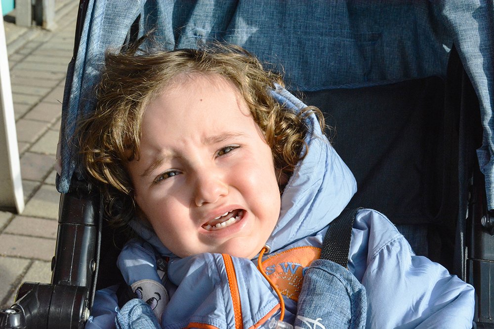 A little kid in the  baby carriage