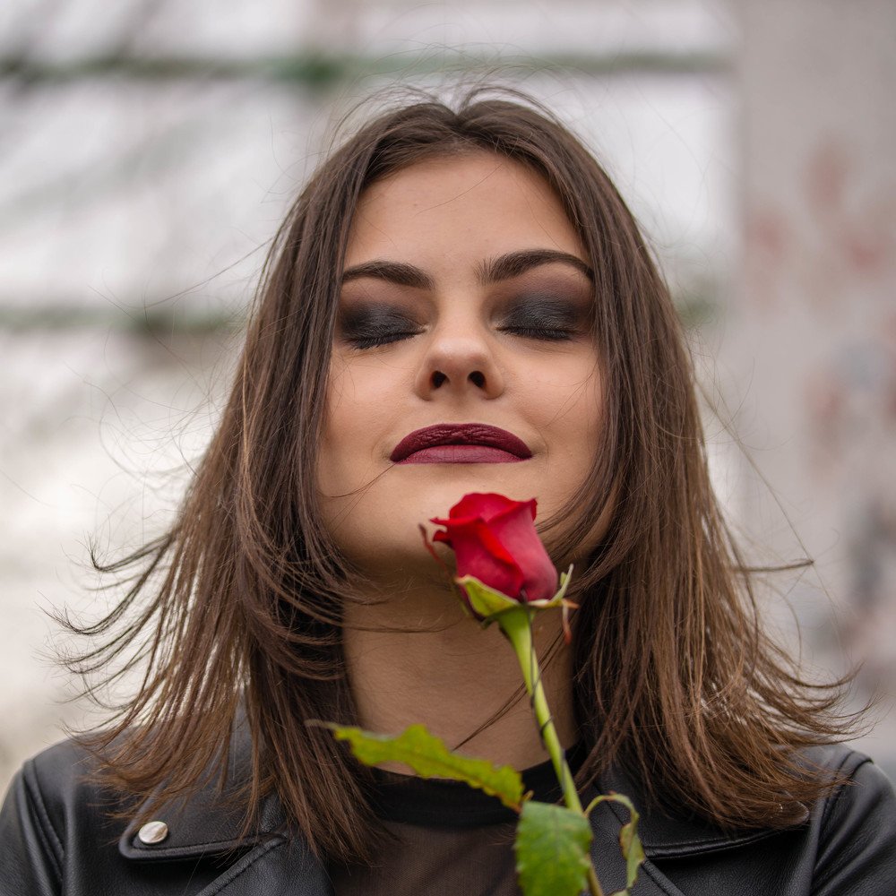 Portrait of pretty young lady with a rose