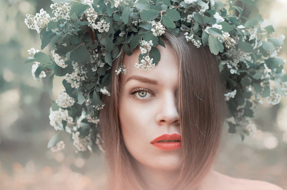 Spring woman portrait with a floral wreath on her head.