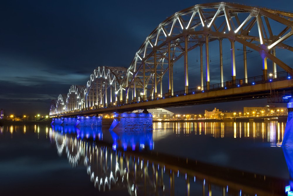 Night panoramic scene with railway bridge in Riga