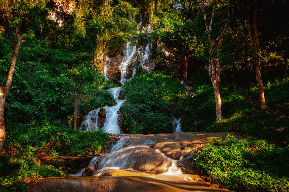 Dreamlike waterfall cascade in green summer forest