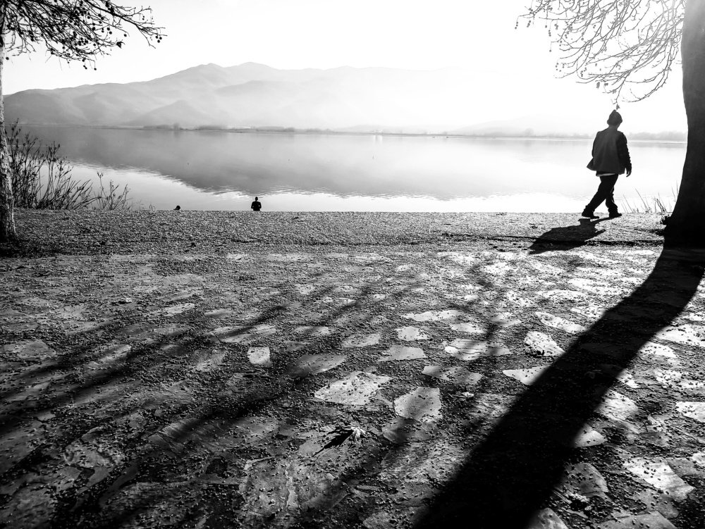man walking by the lake