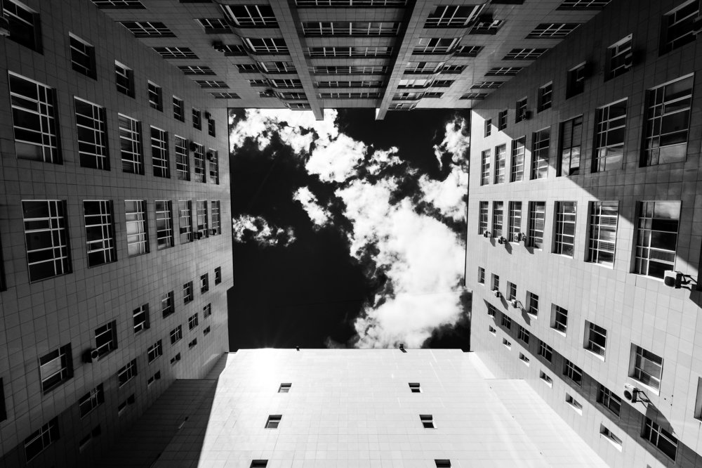 Вид вверх из двора на облака