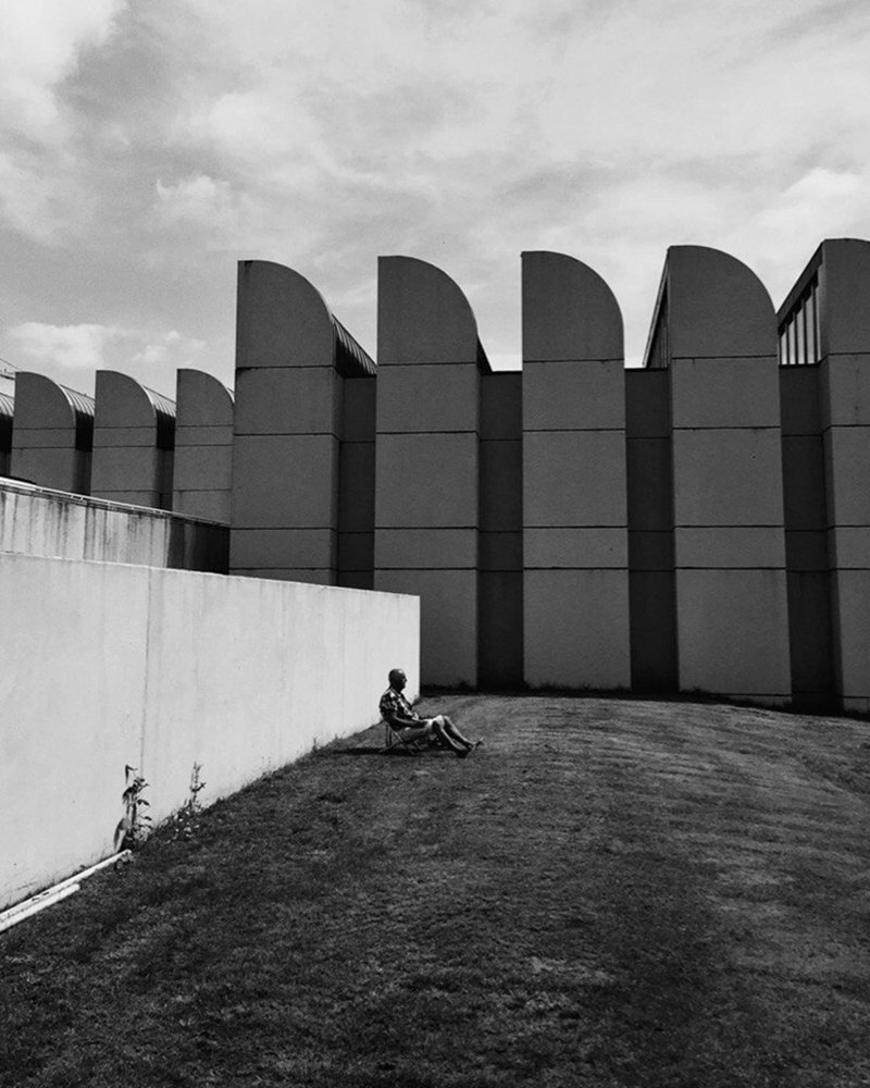 Мужчина, загорающий у здания Баухаус