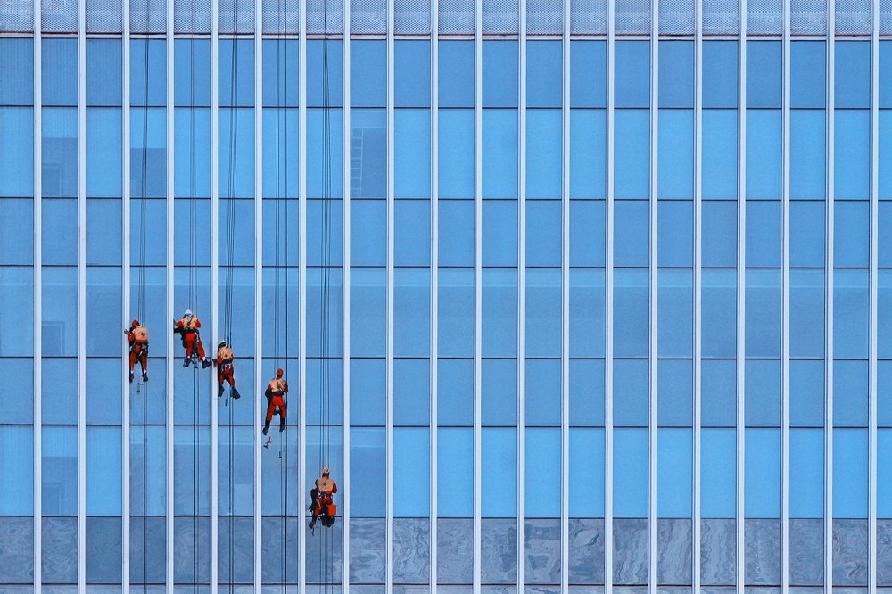Men clean the building glass